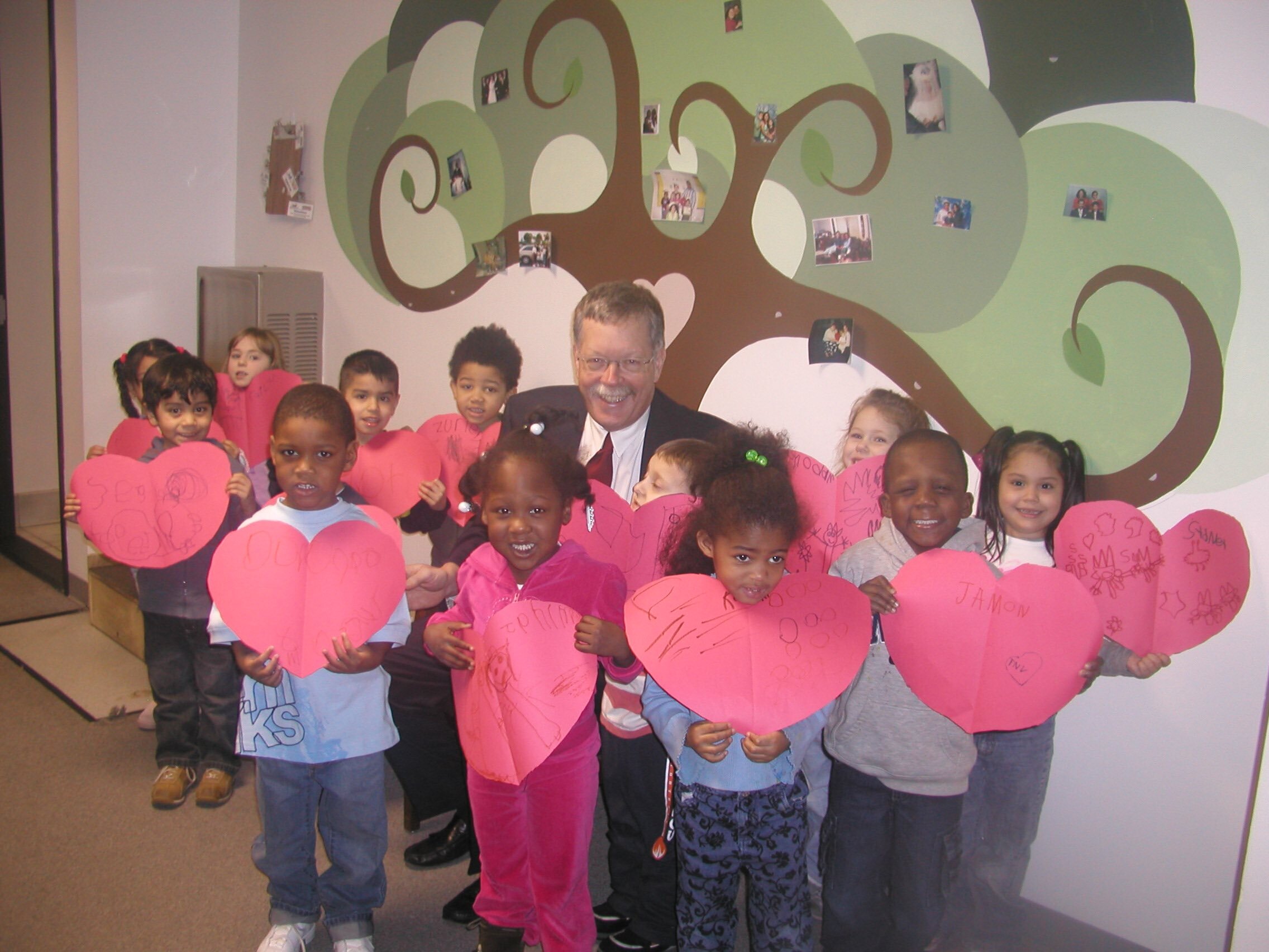  Preschoolers smile with former Oakland Family Services President and CEO Michael Earl at the Pontiac Children’s Learning Center in 2001.  