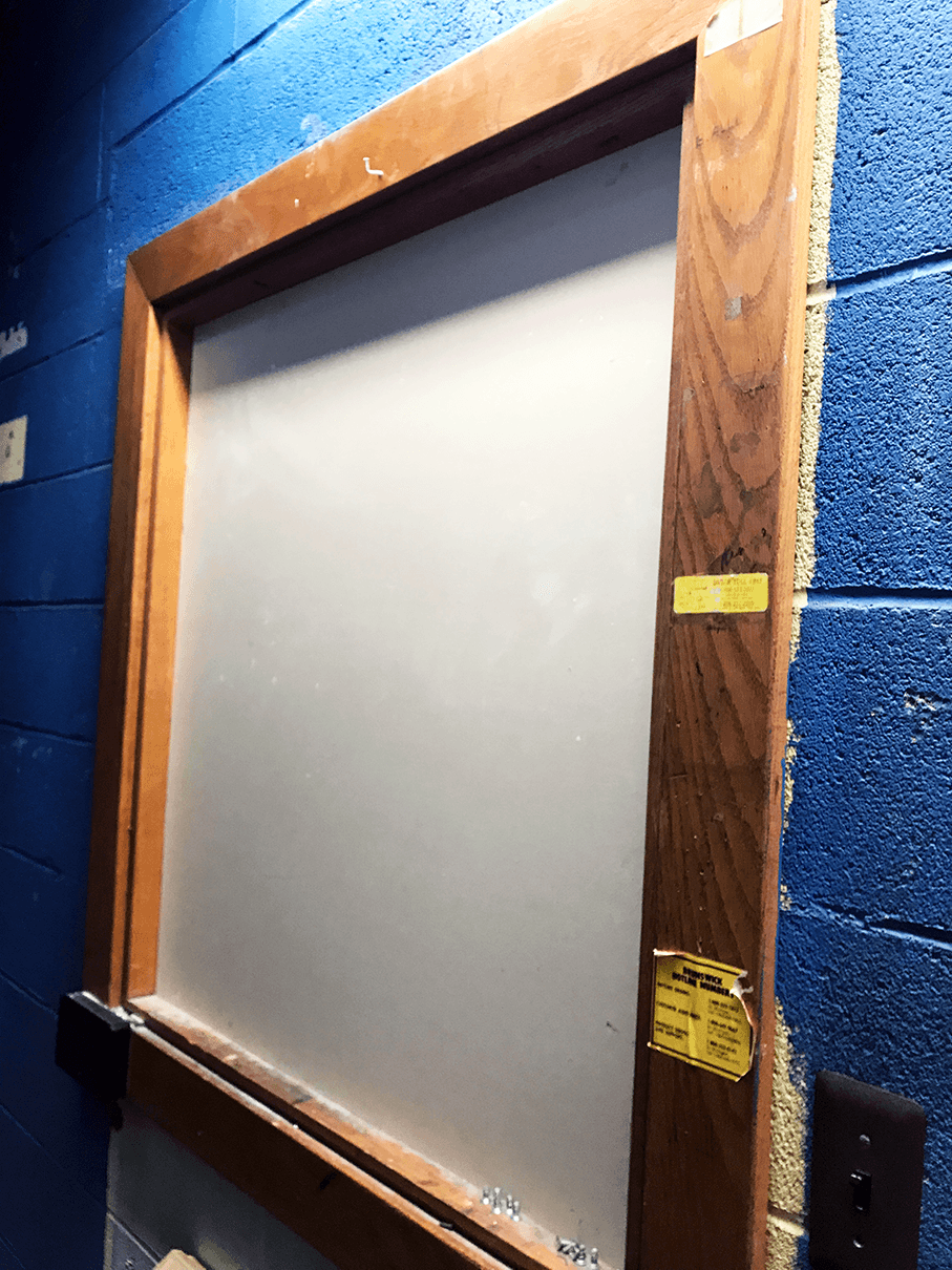  Today, this service window is boarded up, but it used to be a shoe rental window when the building housed a bowling alley. This space is now an office closet, but the blue paint is left over from its bowling alley days. 