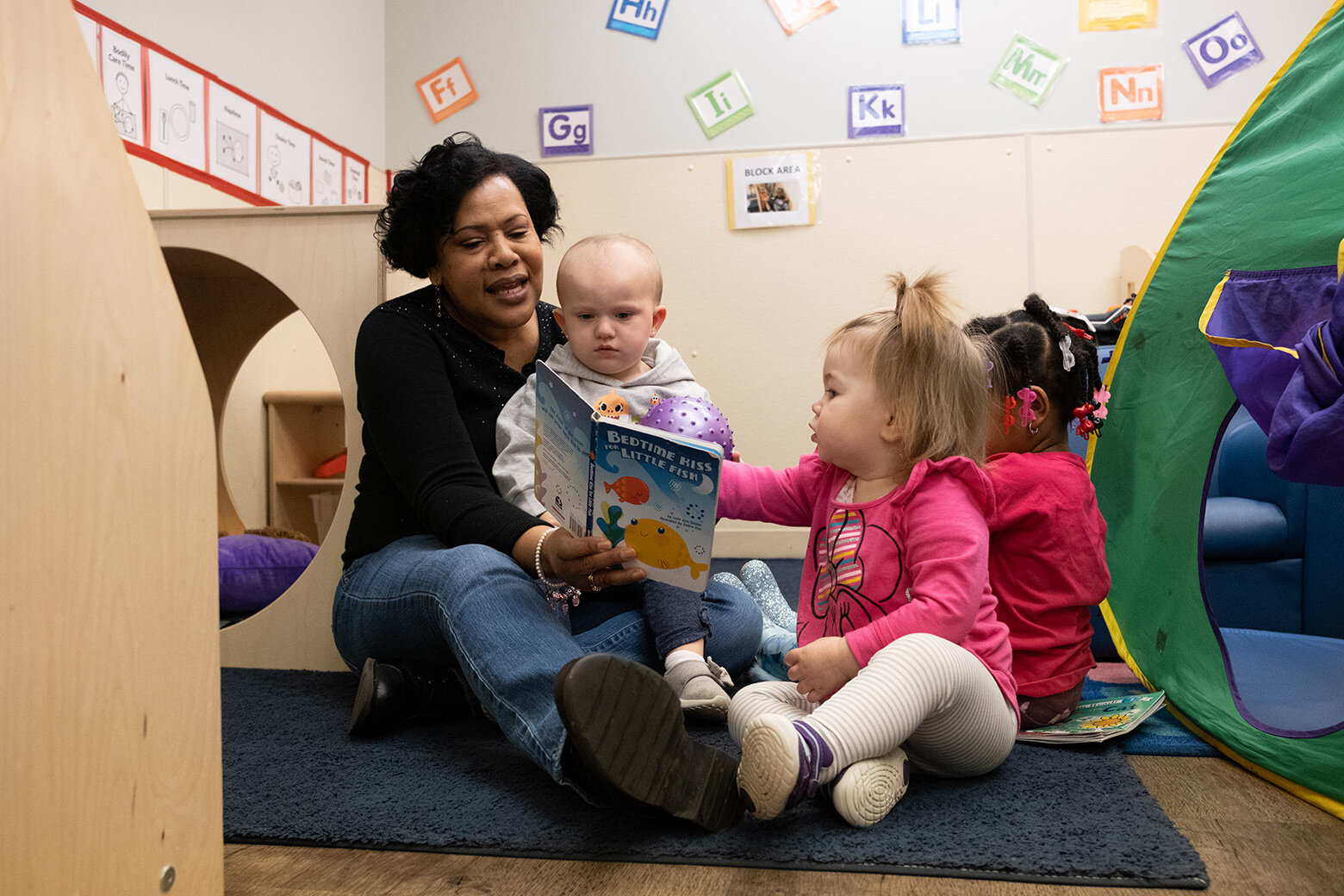 Amelia and two classmates read with their teacher, Jackie Chaney, in 2019. 