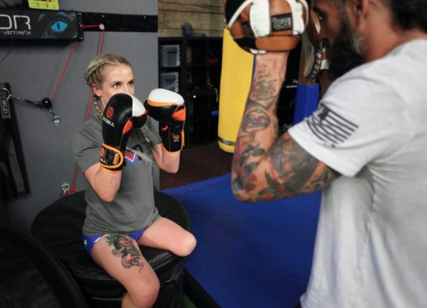 Veteran Kirstie Ennis —who had part of her left leg amputated after injuries from a helicopter crash in Afghanistan—trains for her upcoming Mount Denali climb by boxing. (Gary DeJidas)