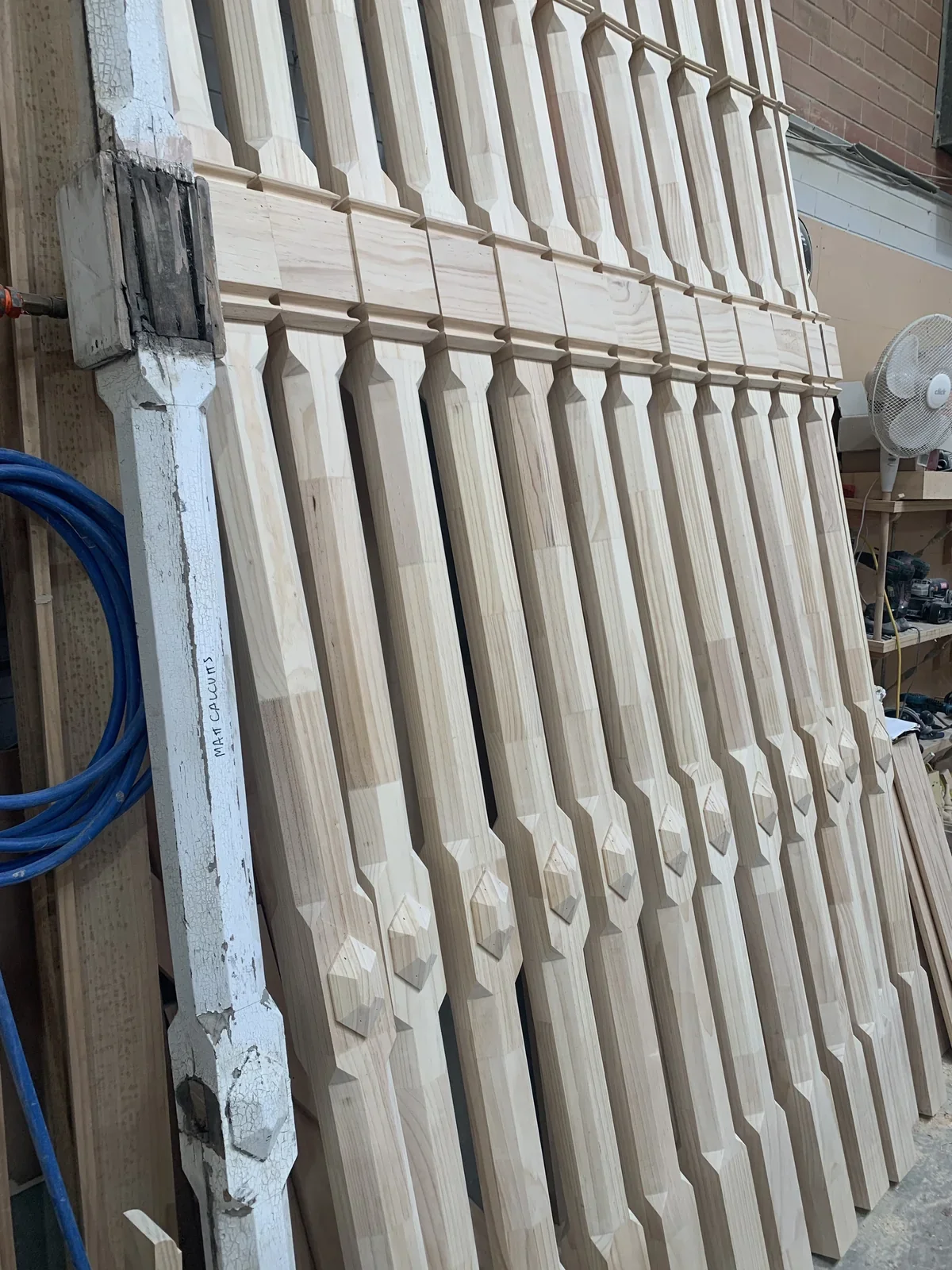 Weathered painted timber pattern beside newly made shaped balusters