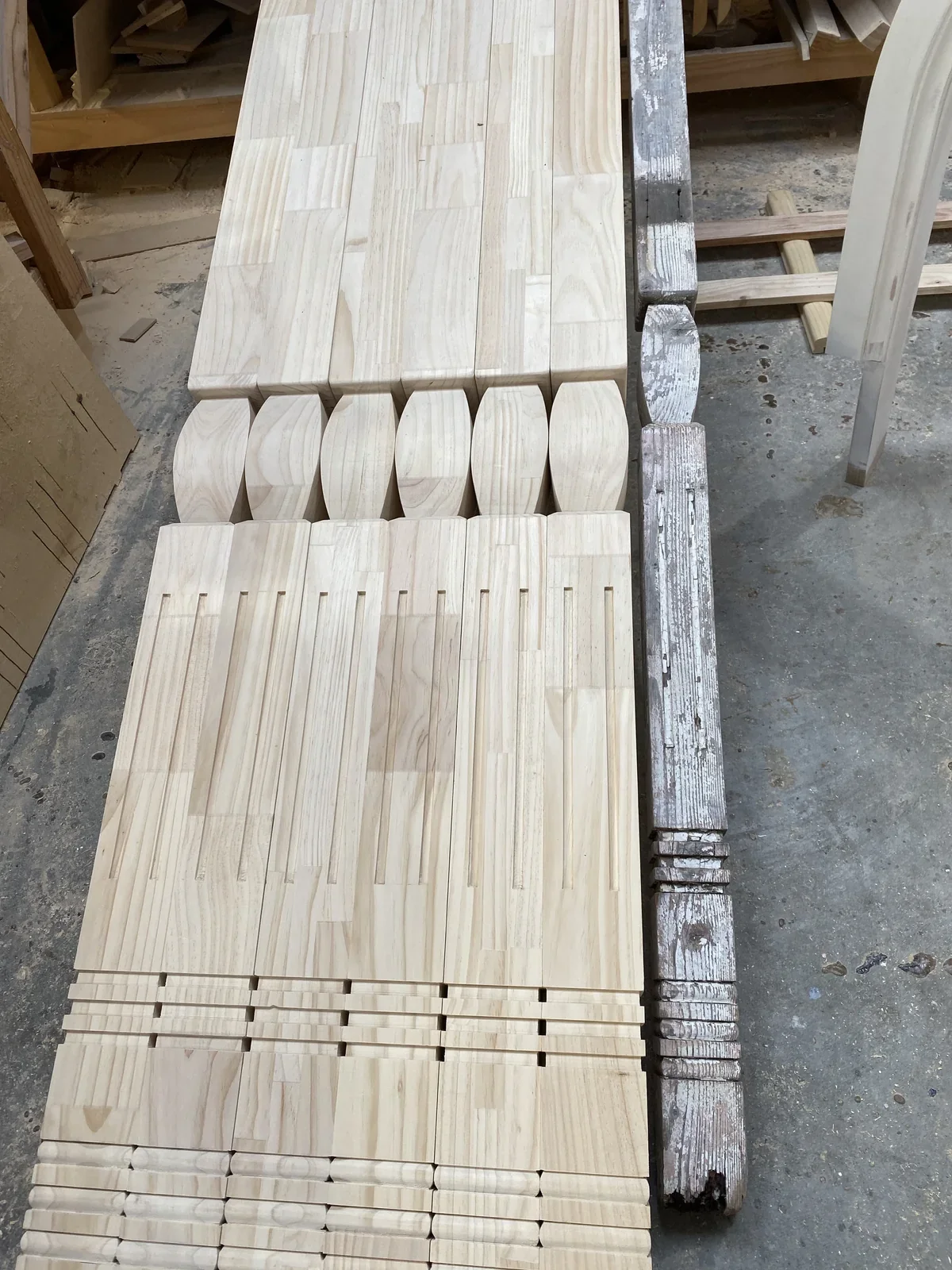 New shaped timber components laid beside a weathered matching reference