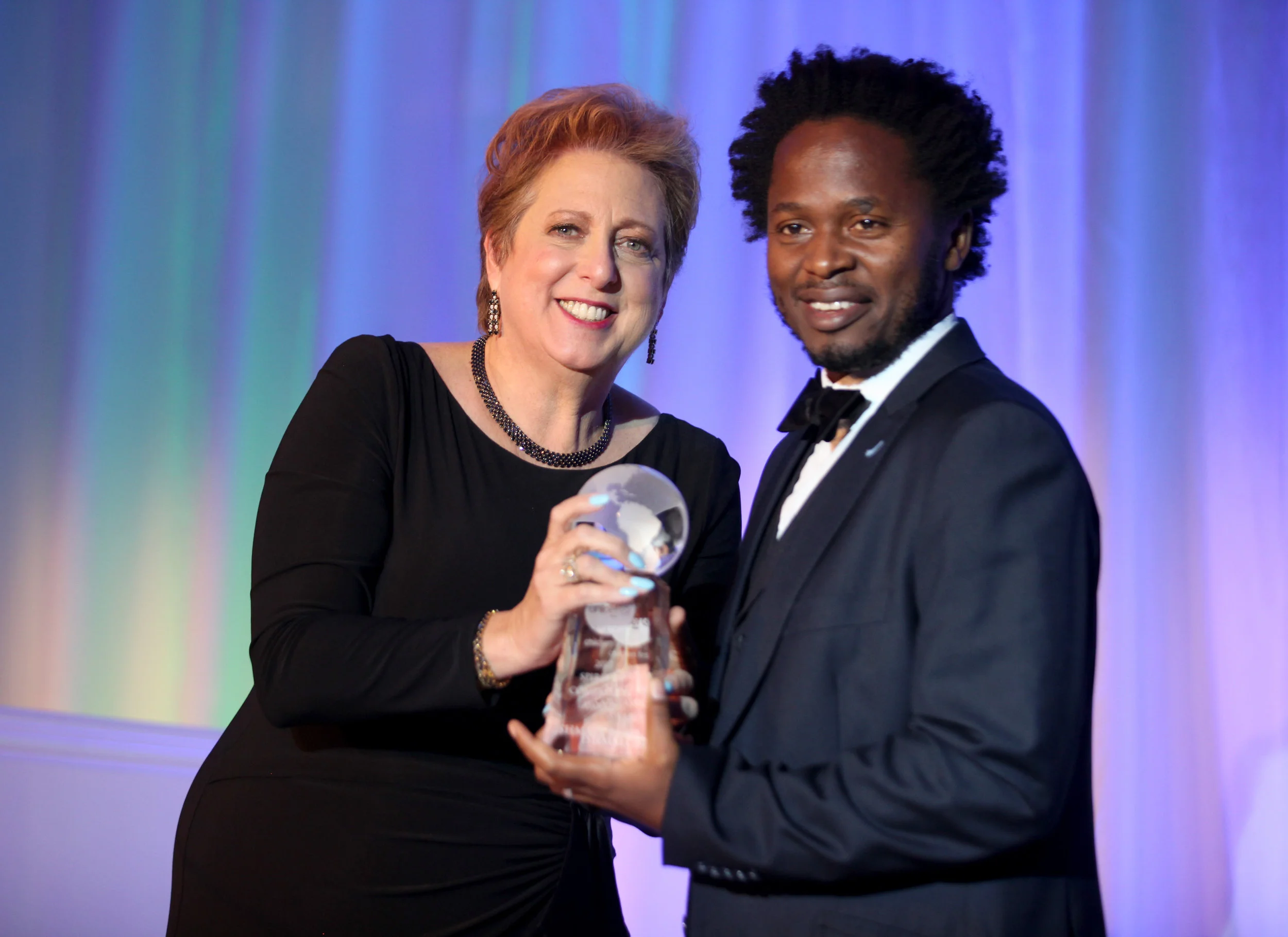 President & CEO Caryl Stern presenting the Spirit of Compassion Award to UNICEF Goodwill Ambassador Ishmael Beah (Photo by Getty Images)