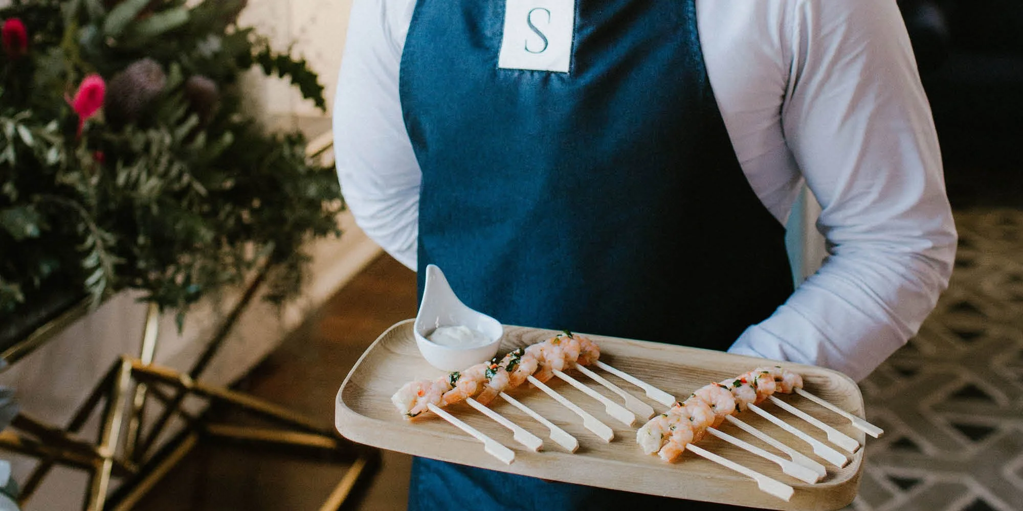 Samphire Catering server holding prawn platter