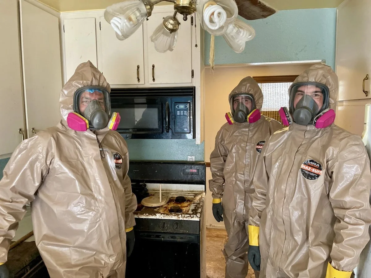 SSM crew in hazmat suits and respirators inside a drug-contaminated home kitchen