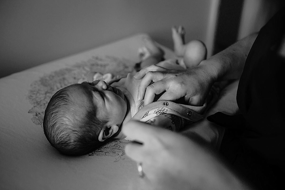 Baby girl crying while mum changes her