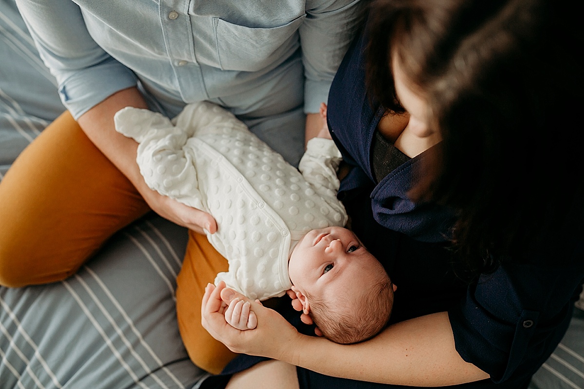 baby laying on parents looking up at them