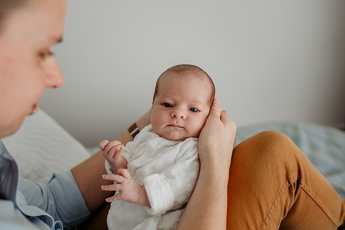 baby resting in dads hands