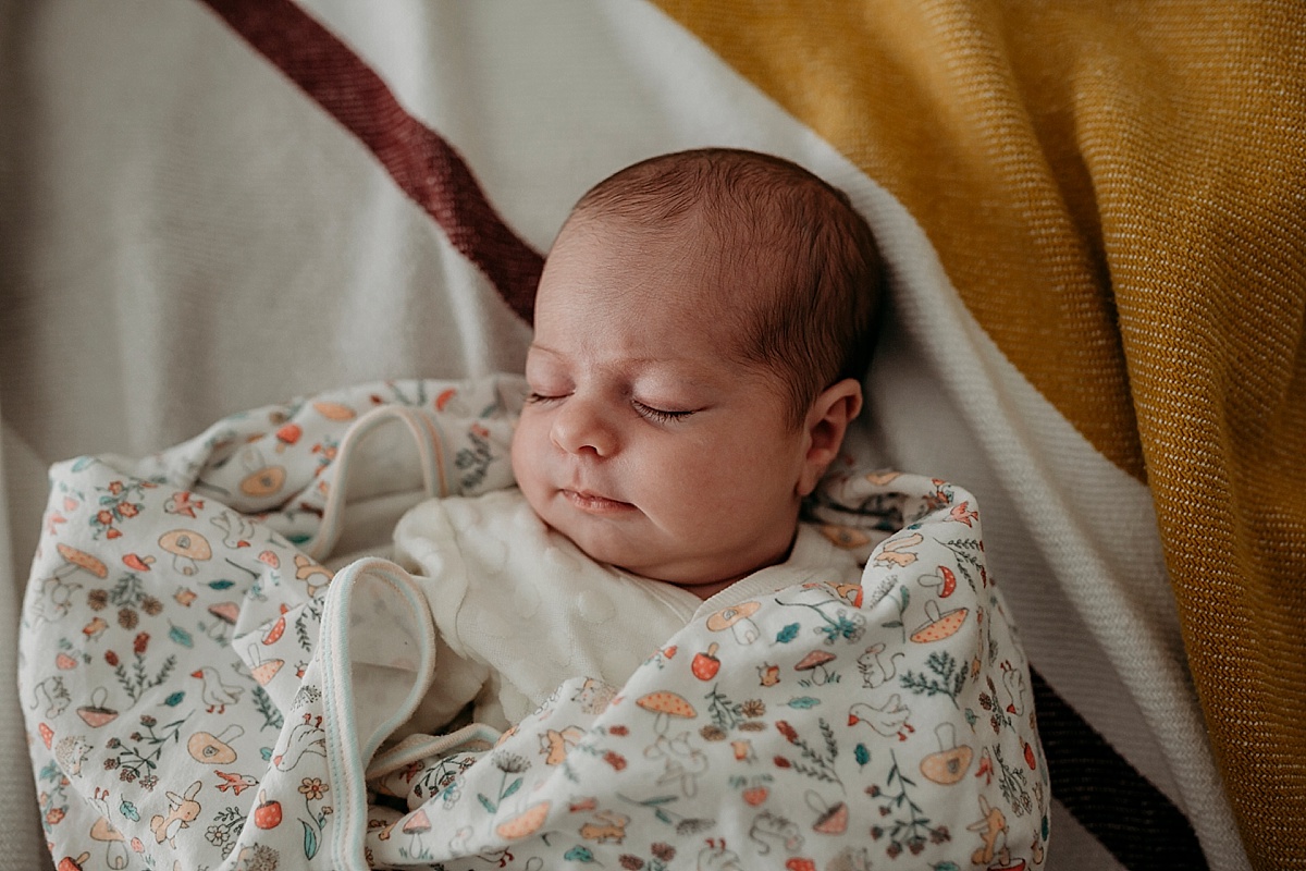 baby asleep on bed slightly unwrapped