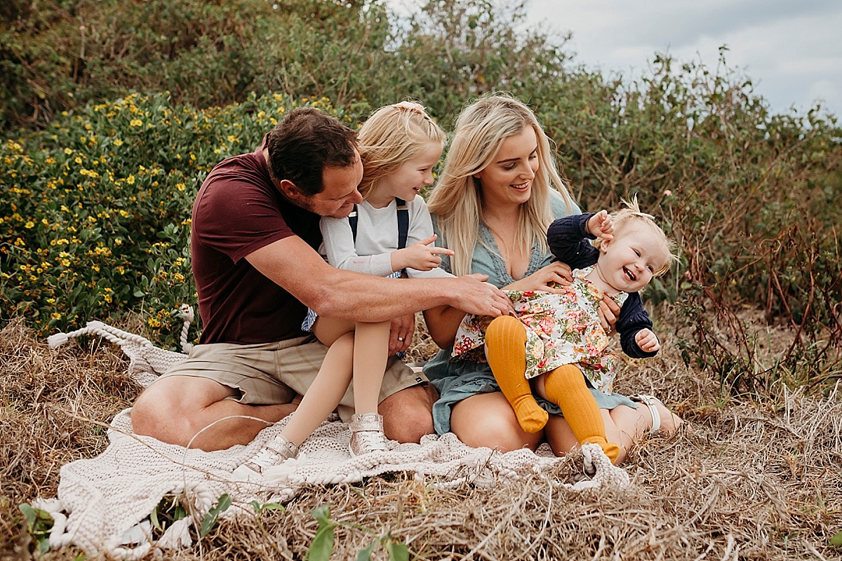 Family sitting, tickling daughter