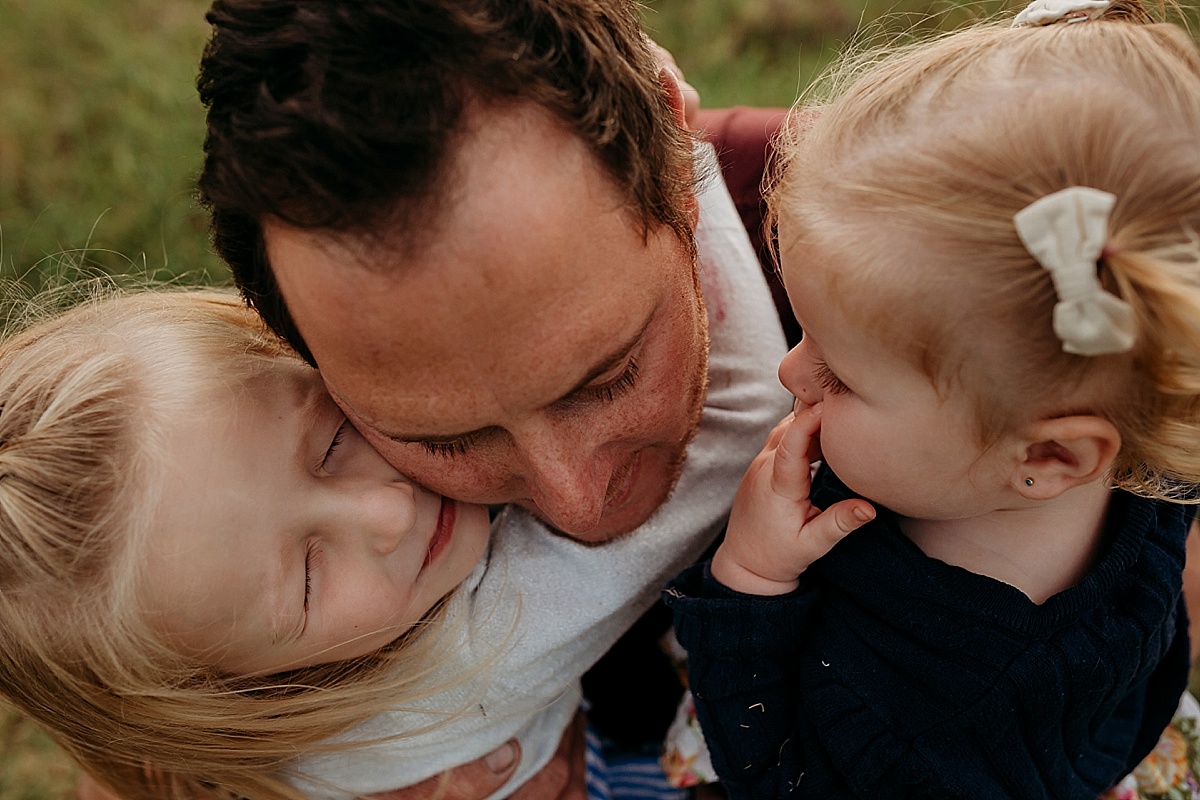 dad and little girls cuddling him