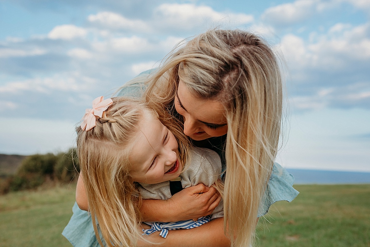mum hugging daughter from behind