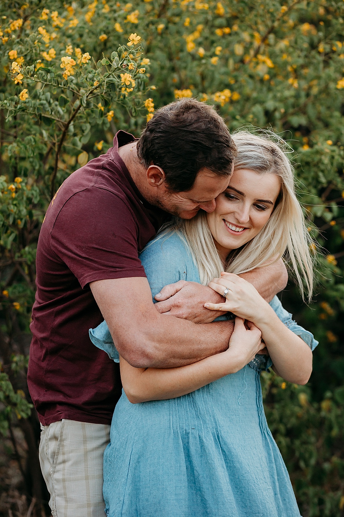 Husband wrapping arms around his wife