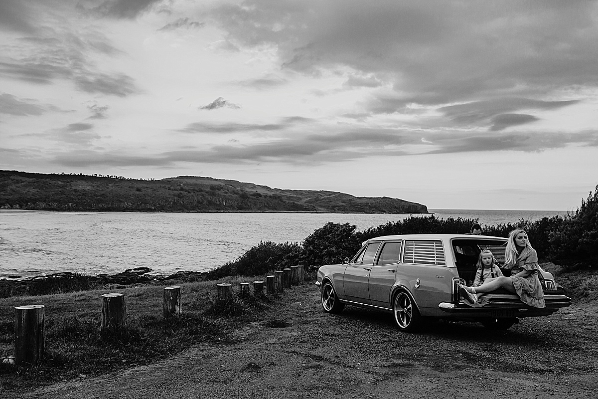 Mum and daughter relaxing on tailgate of car