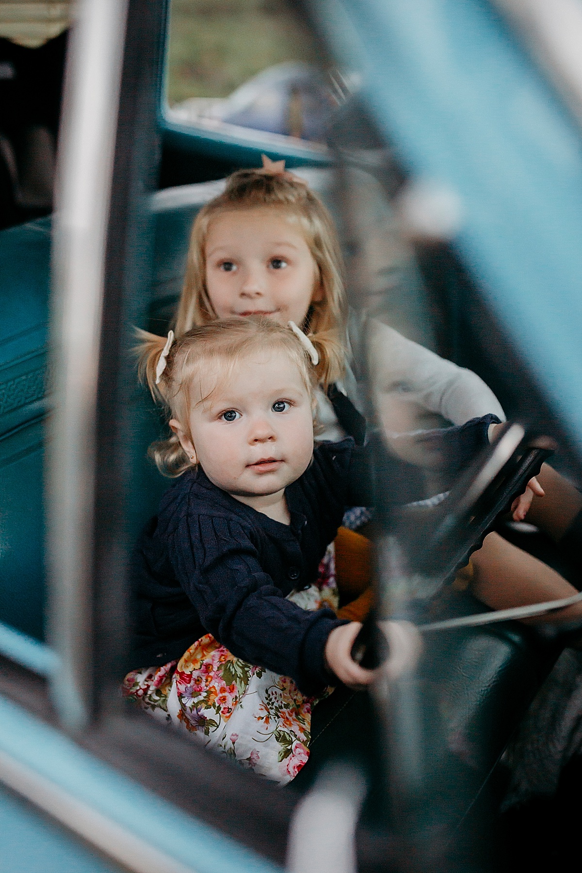 Two girls pretending to drive parents car