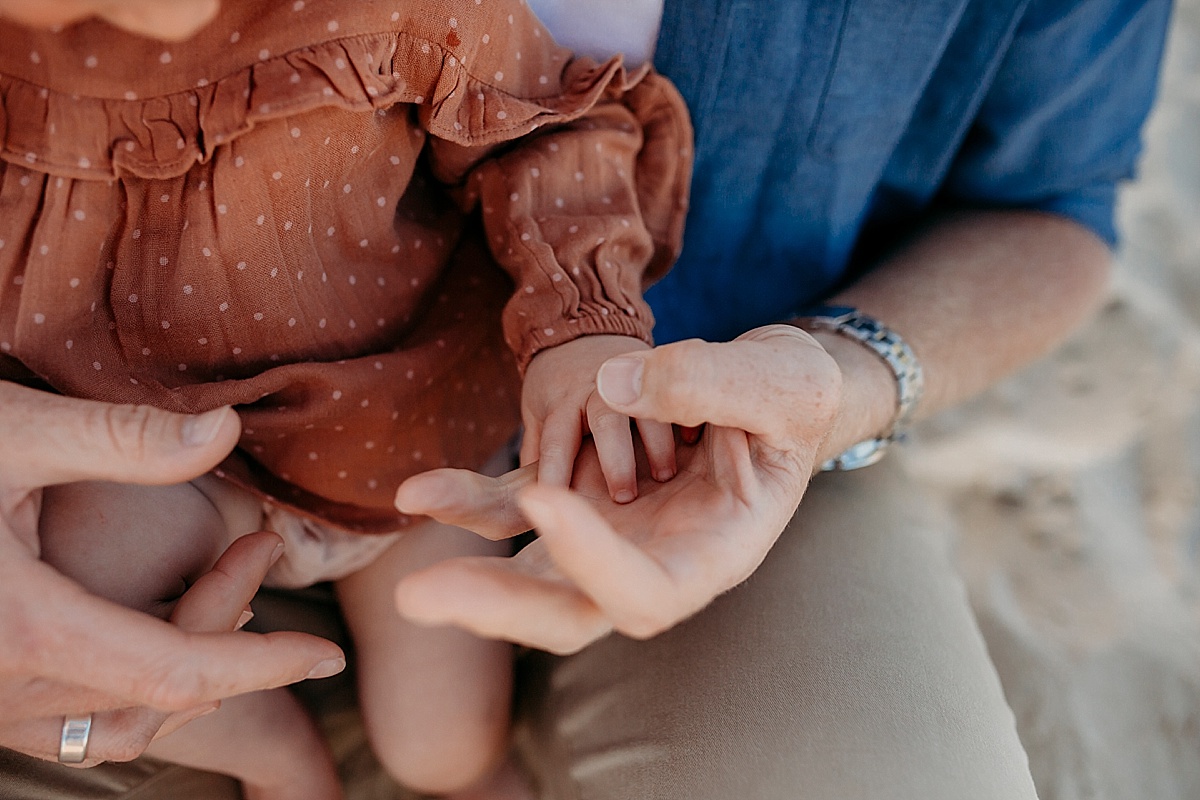 Baby girls hand resting on fathers palm