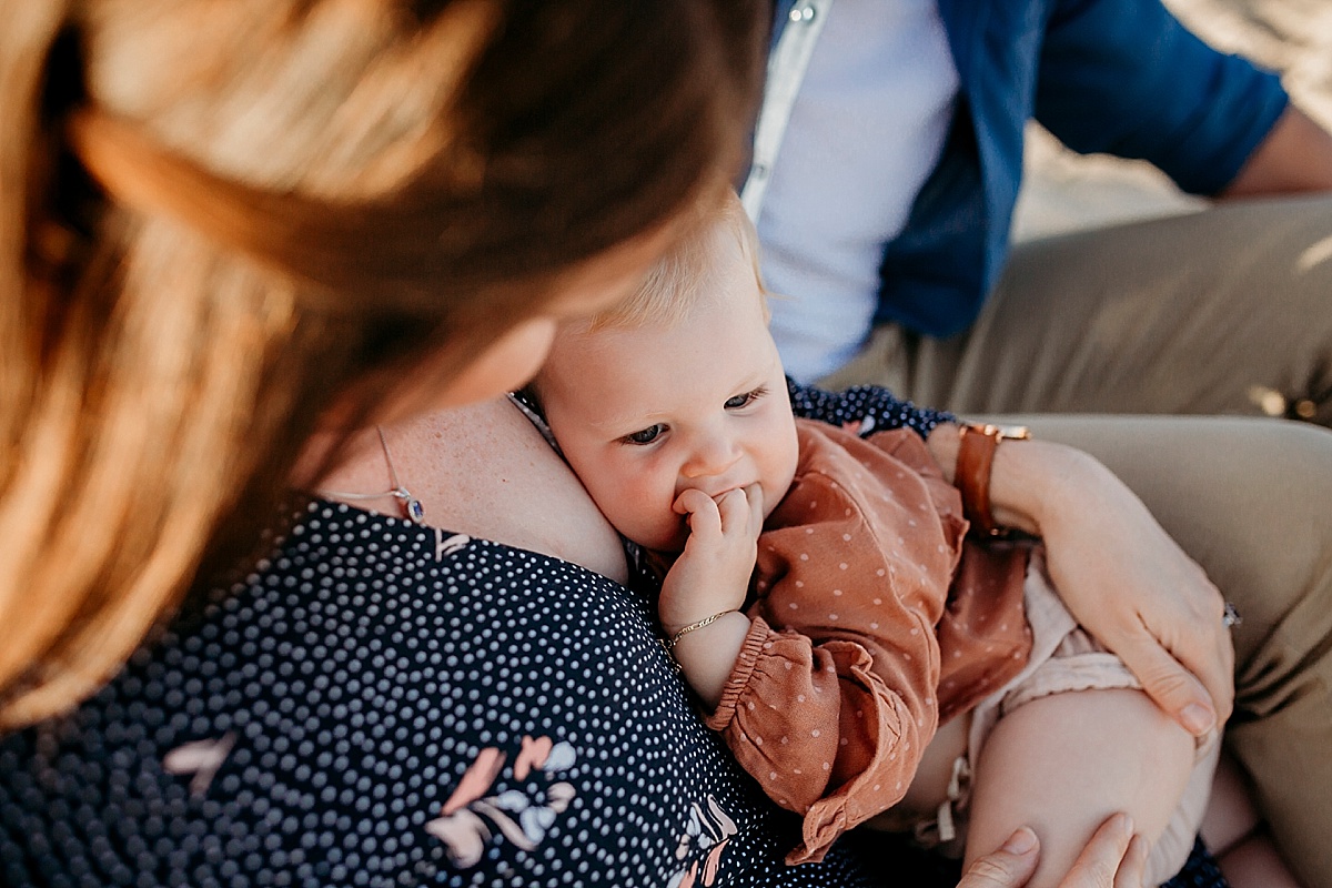 baby girl snuggling into mum while sitting on her lap