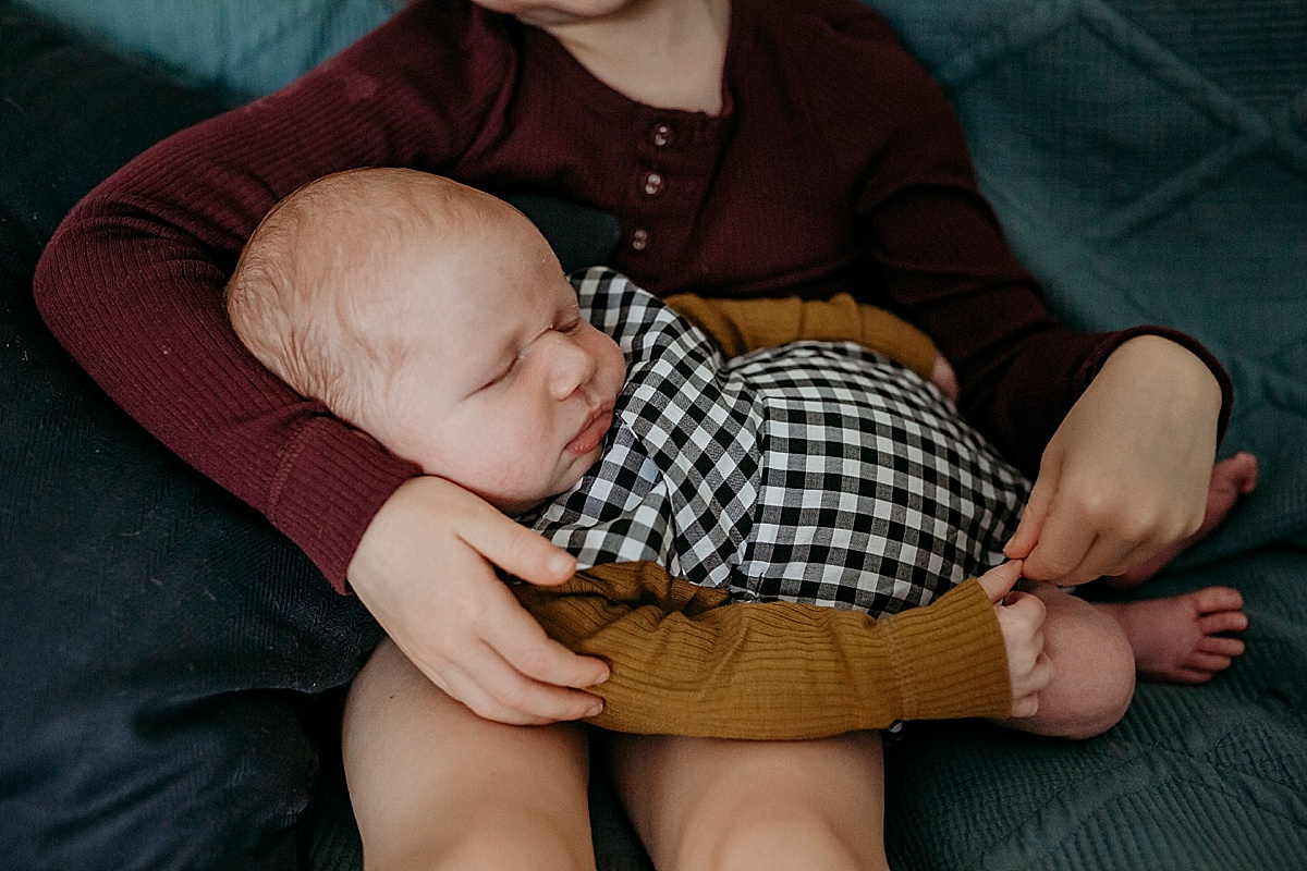 newborn baby in little girls arms