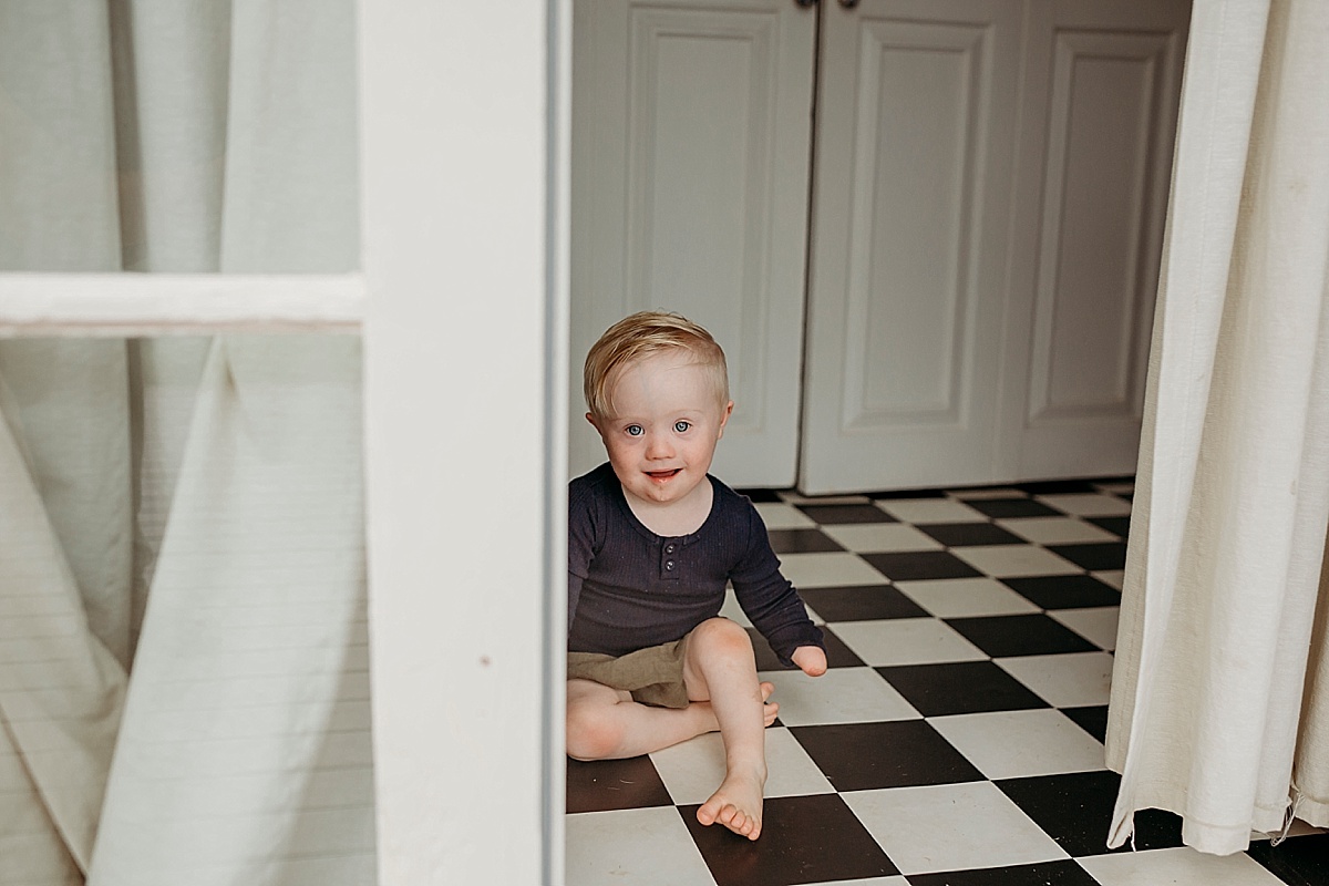 toddler with down syndrome and one had sitting on black and white floor just inside french doors