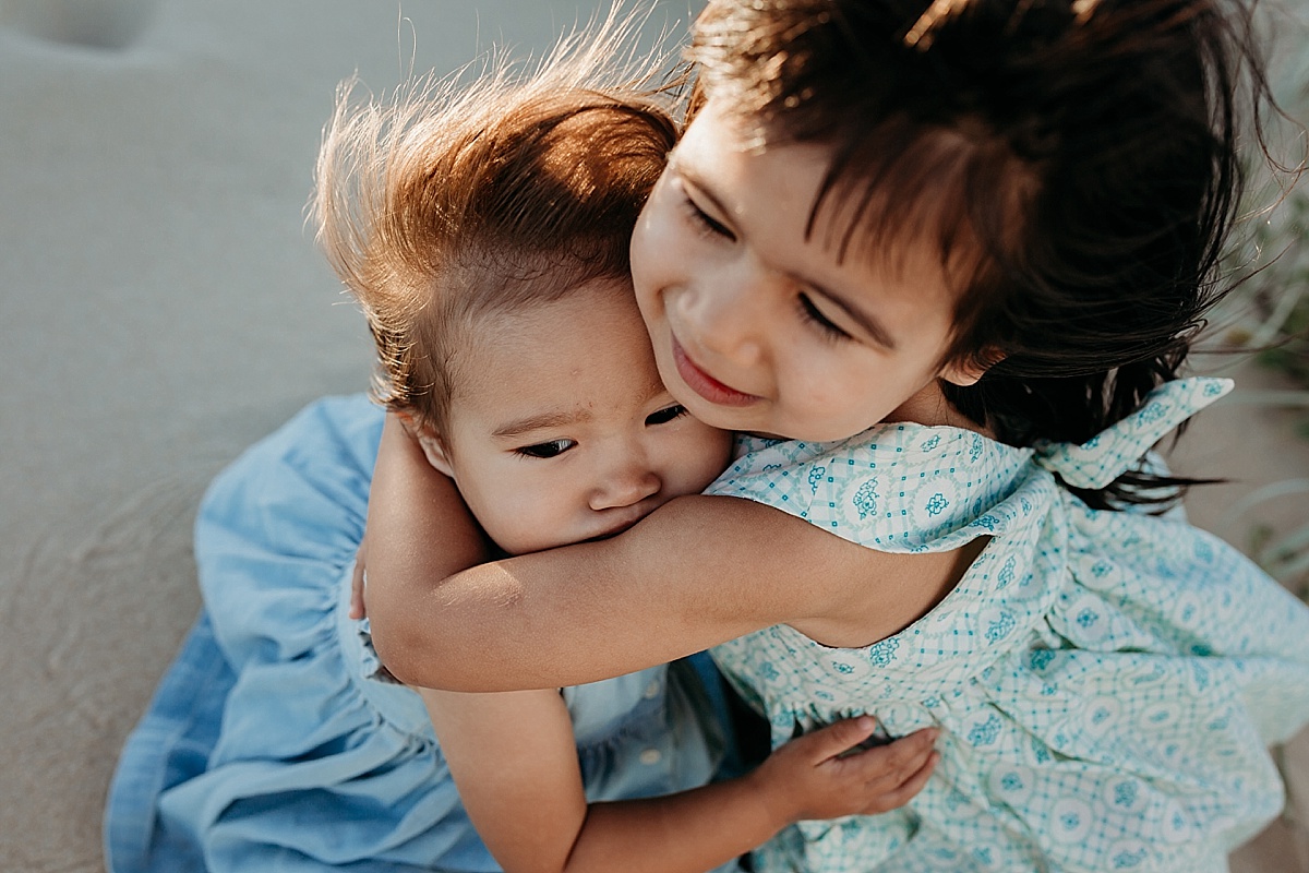 Big sister hugging little sister