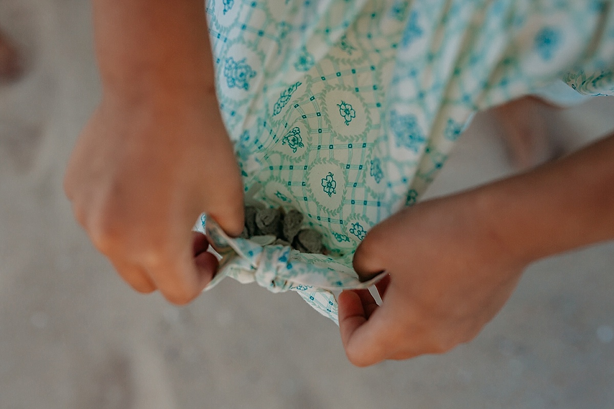 Little girl holding pocket open for me to see shells inside