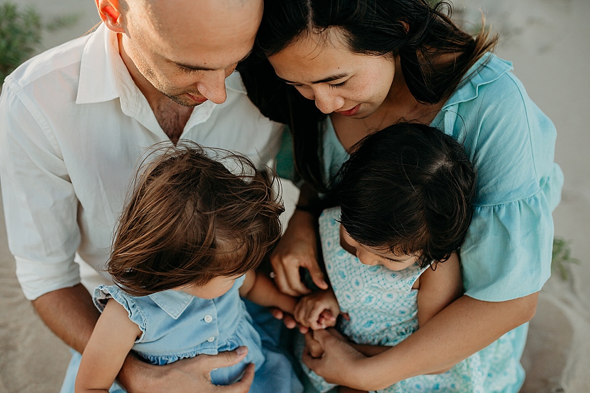 Family cuddles on beach at photography session