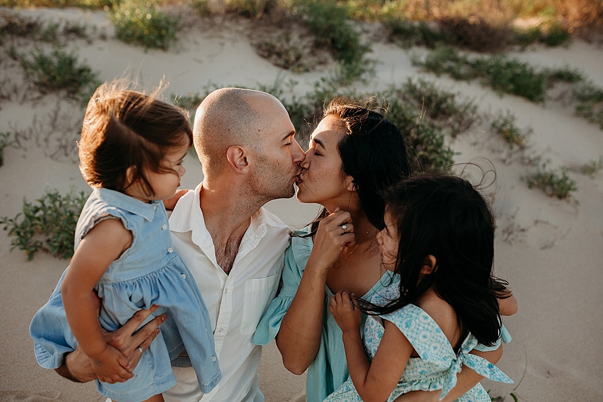 Mum and dad having a kiss while kids laugh