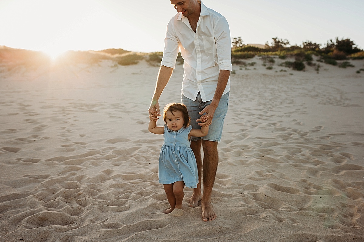 dad hand in hand with baby girl
