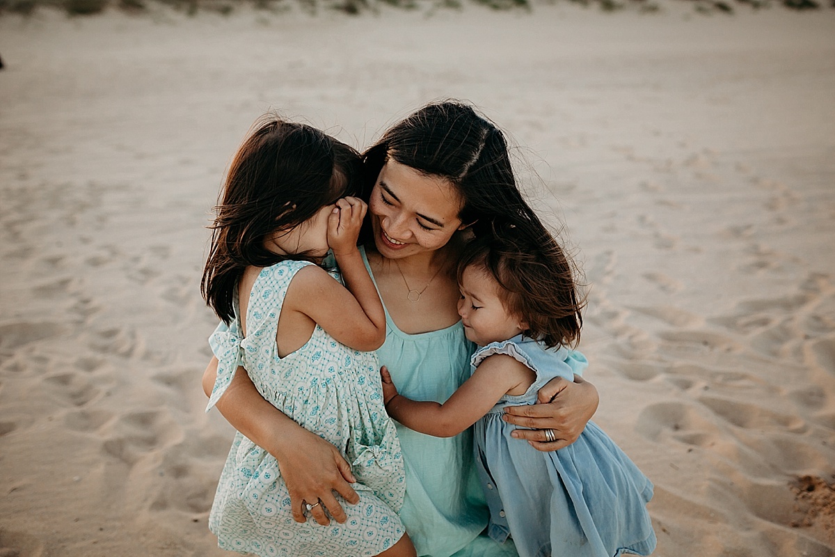 two little girls hugging their mum