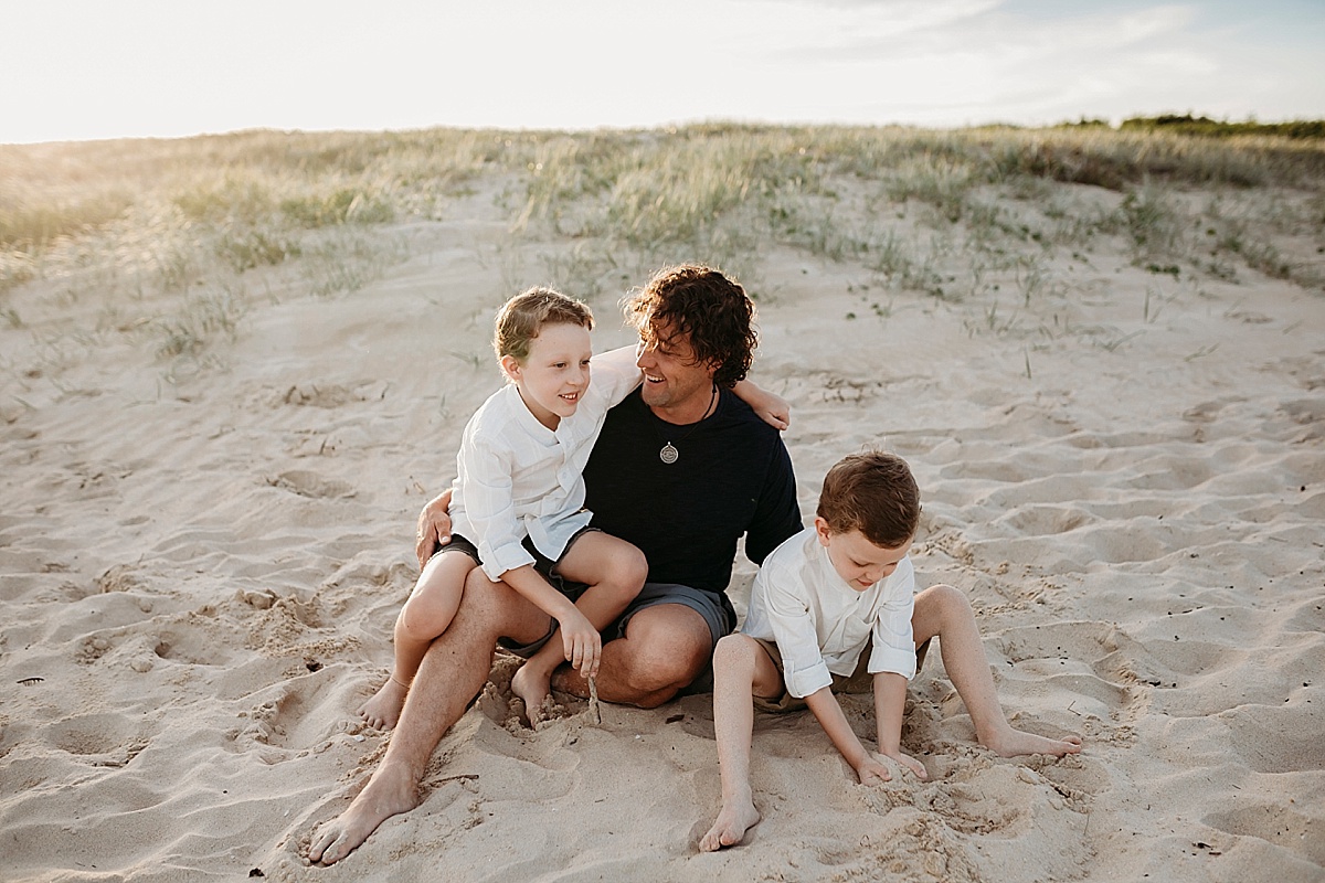 Dad and his boys sitting on the beach