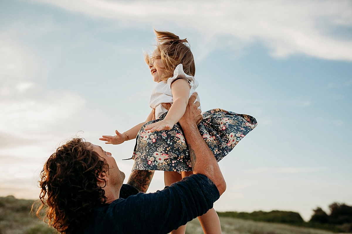 Little girl getting tossed into air by dad