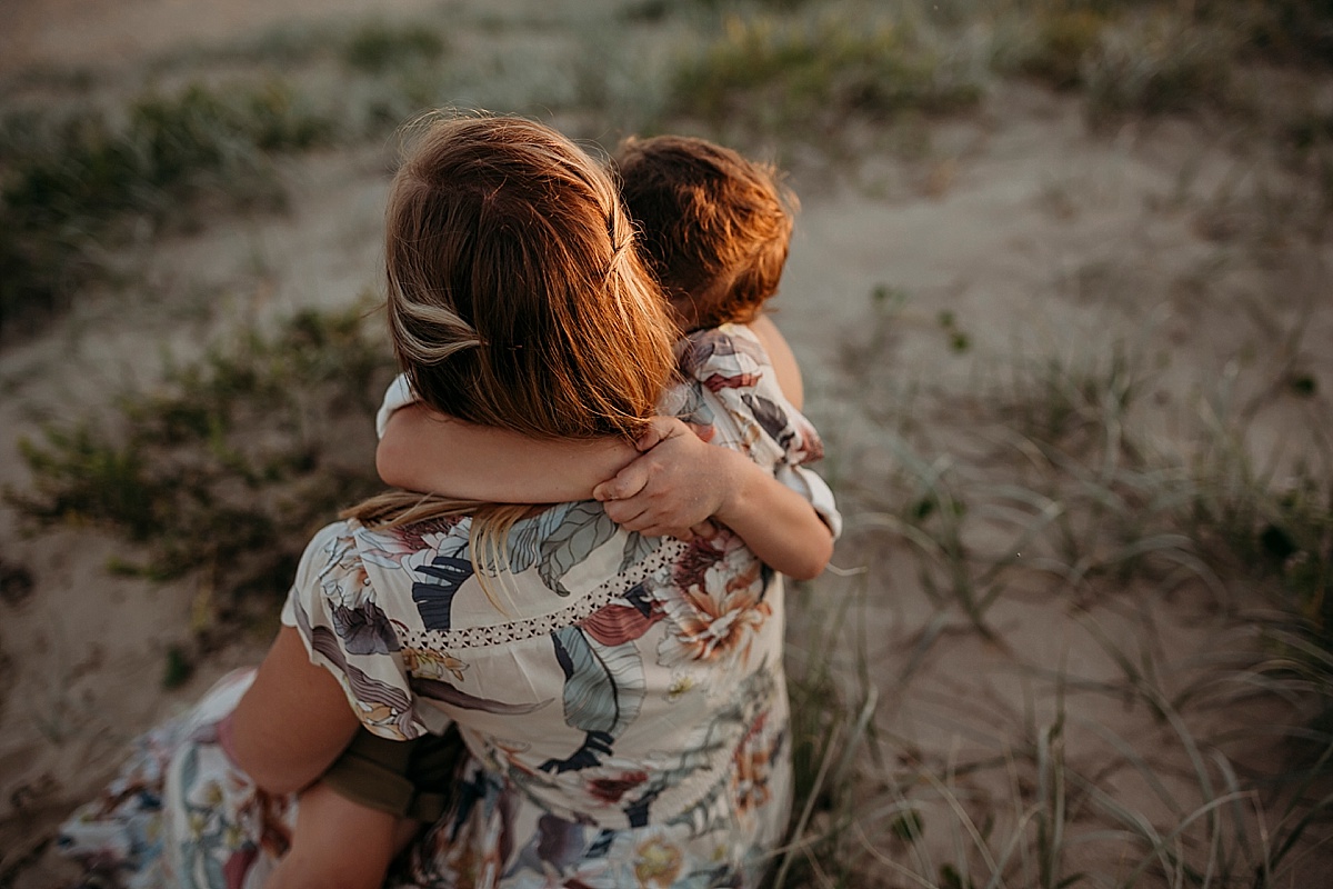 Boy wrapping arms around mums shoulders
