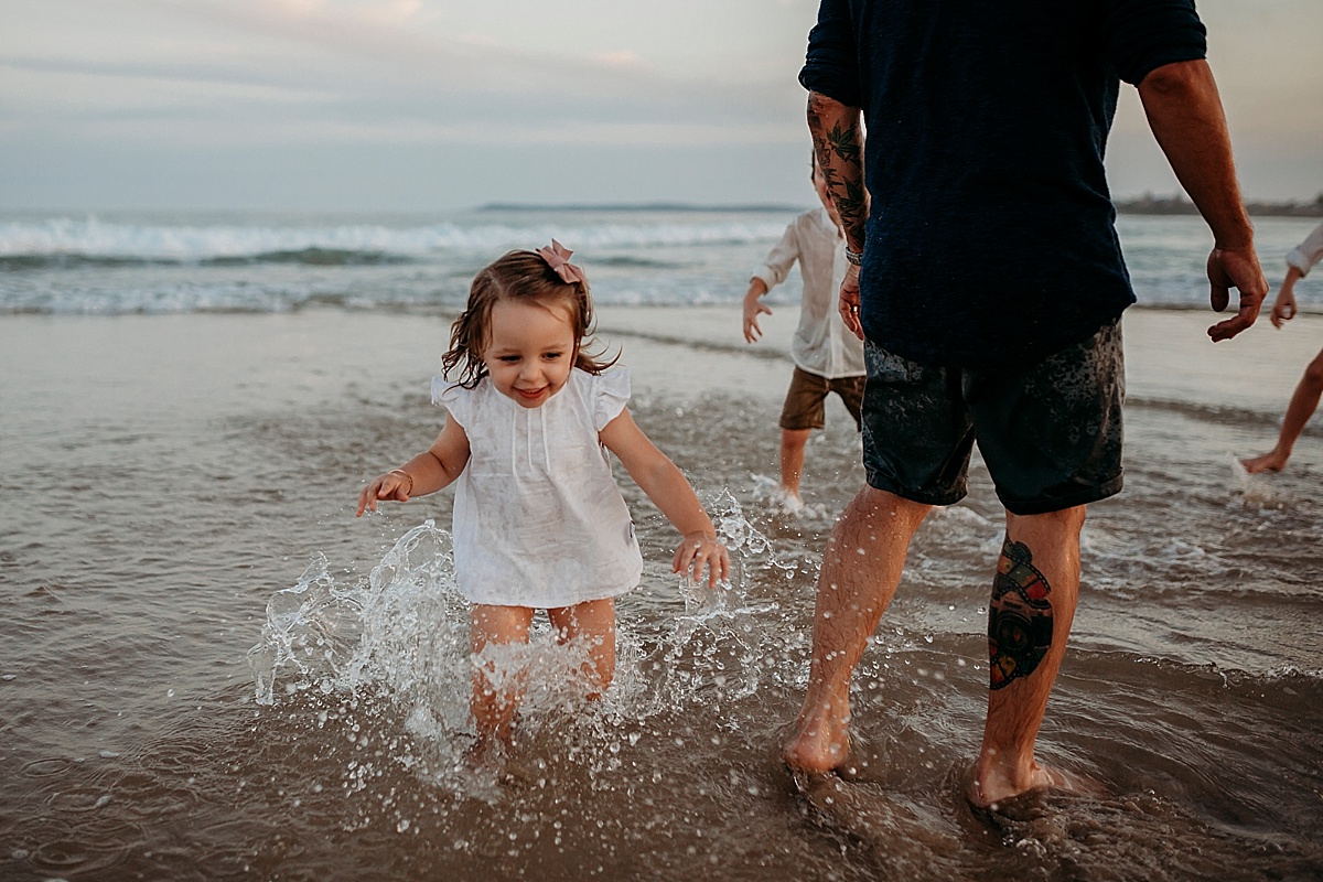 Little girl running through beach water