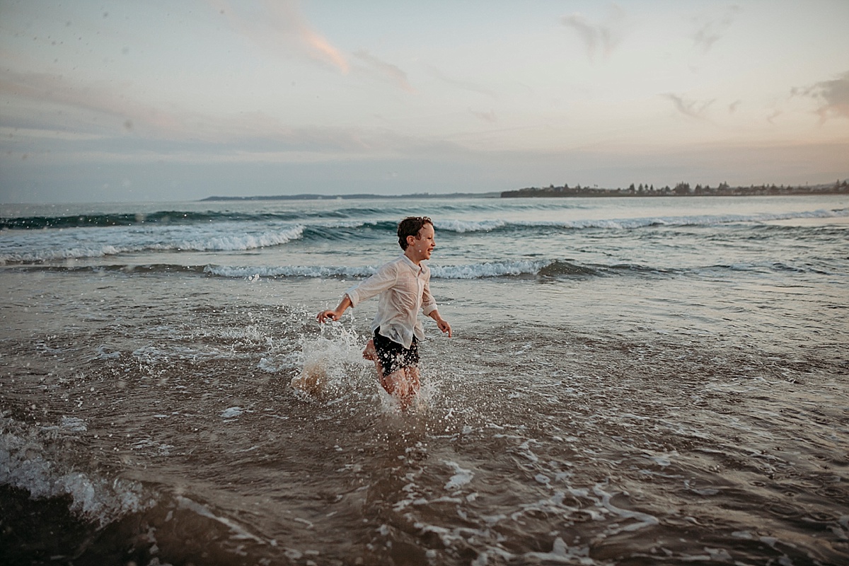 boy playing in the ocean