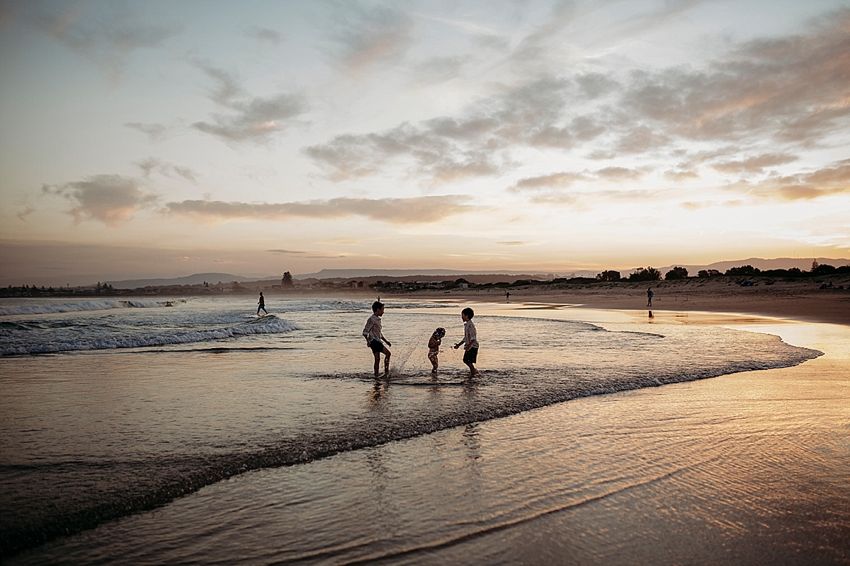 siblings at beach at sunset