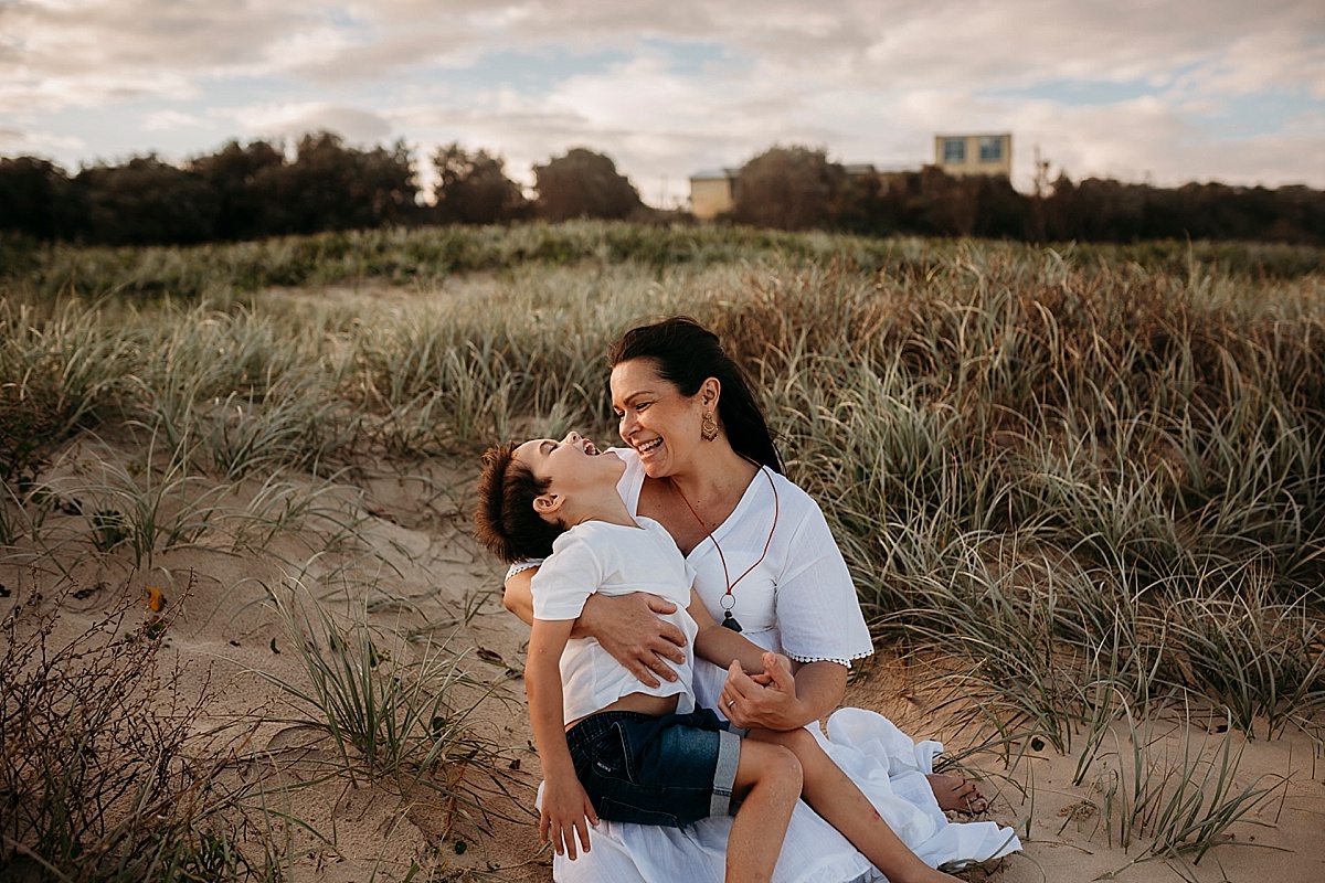 mother and son laughing together on beach