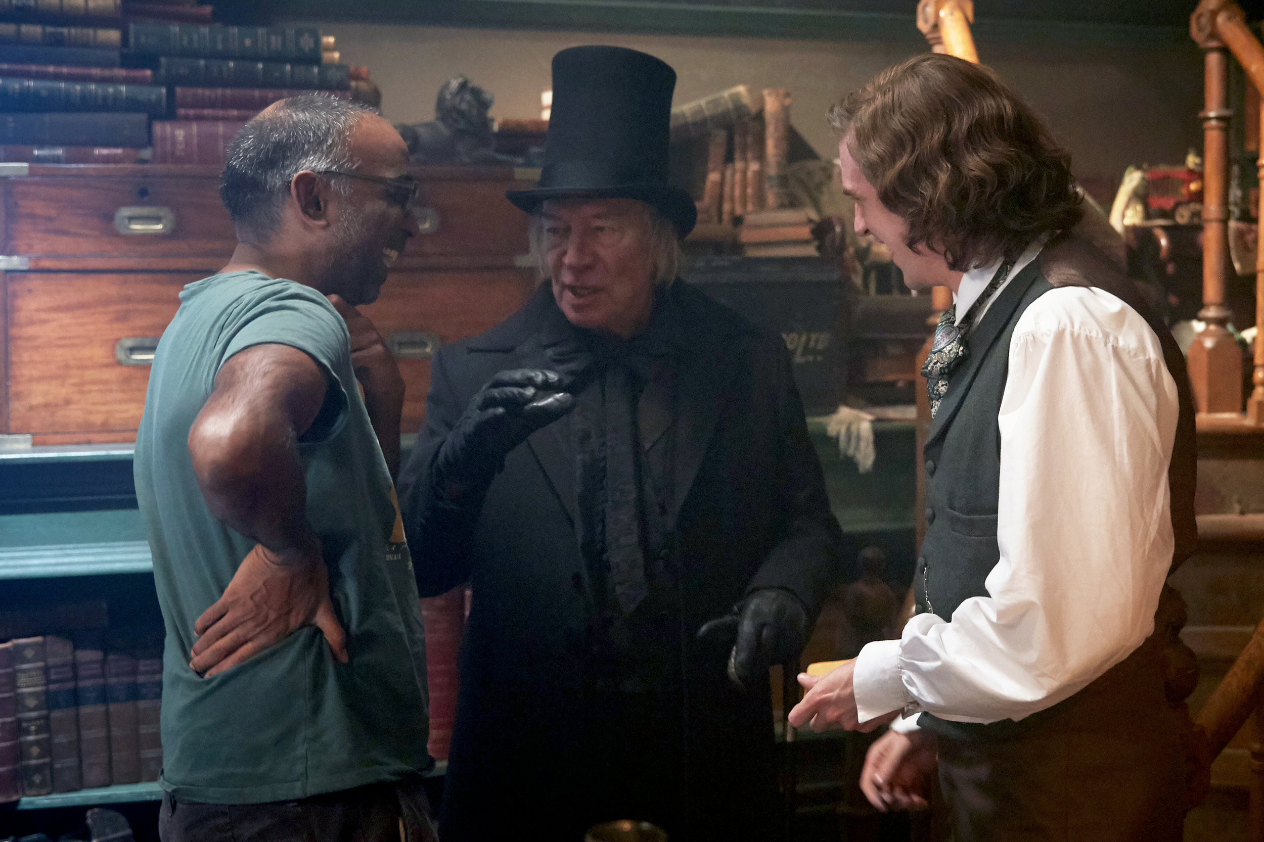 Director Nalluri talks over a scene with Scrooge (Plummer) and Dickens (Stevens)