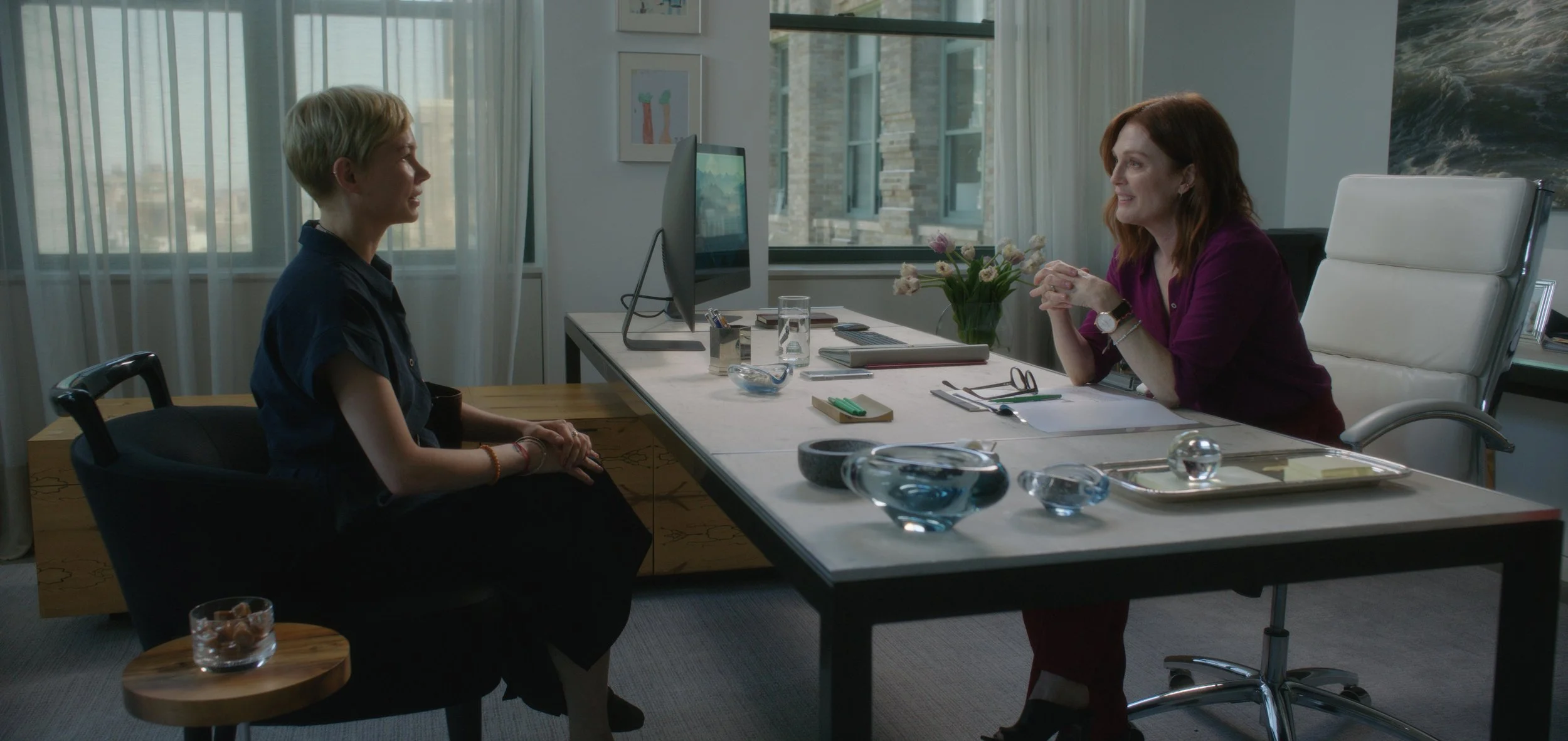 Julianne Moore is a business mogul stringing along the director of an Indian orphanage (Michelle Williams)