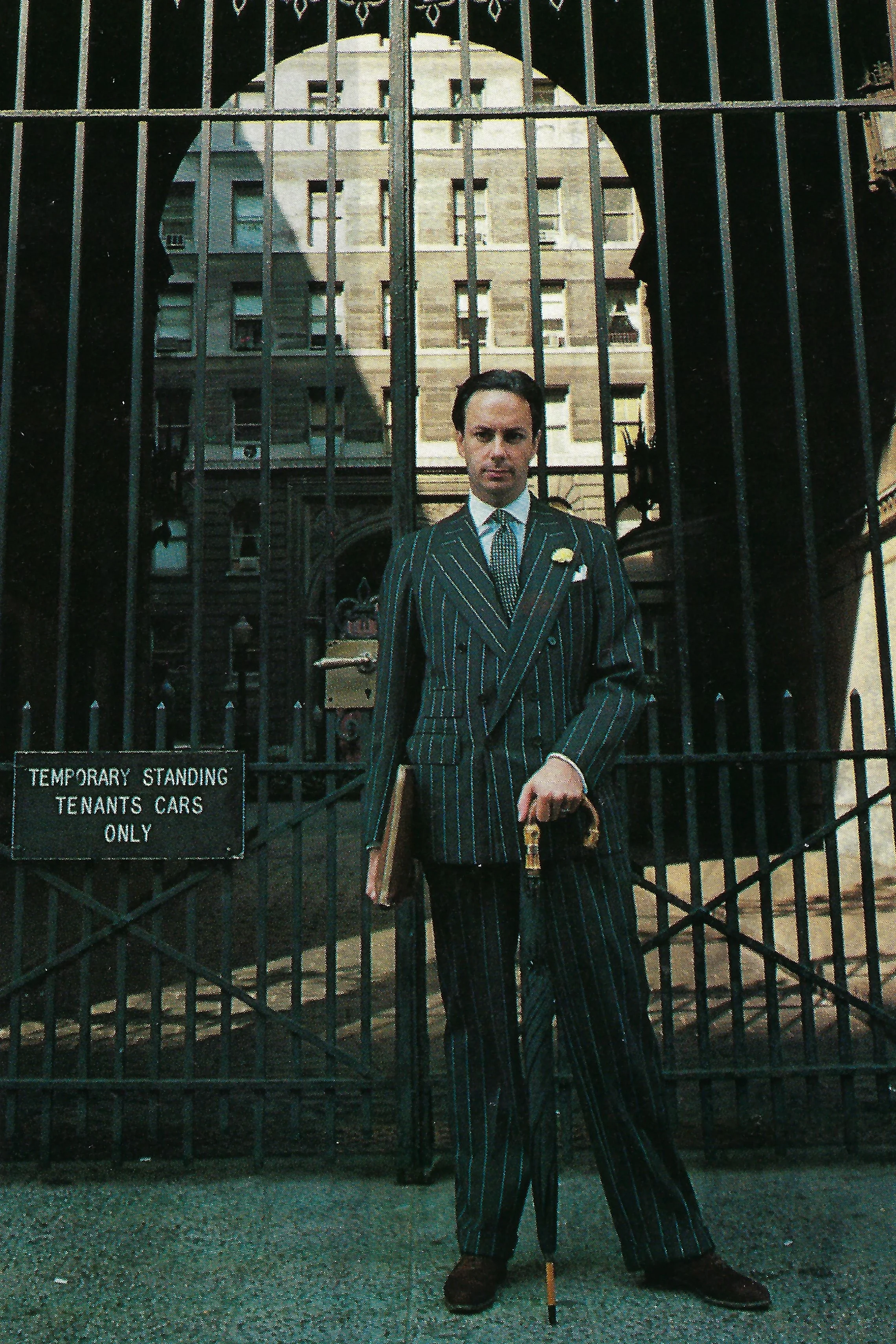 Our sartorial gatekeeper, in the suit made famous by the Prince of Wales (or was it the suit that made the Prince?): chalk-striped double-breasted flannel in a soft drape cut. Brown suede shoes complete the royal salute.