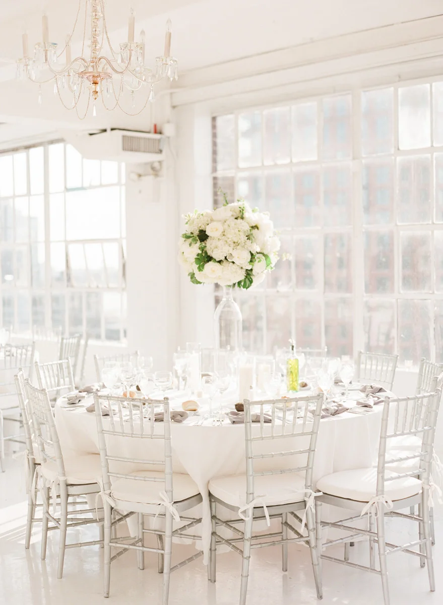 Tall white centerpiece with white roses and hydrangea