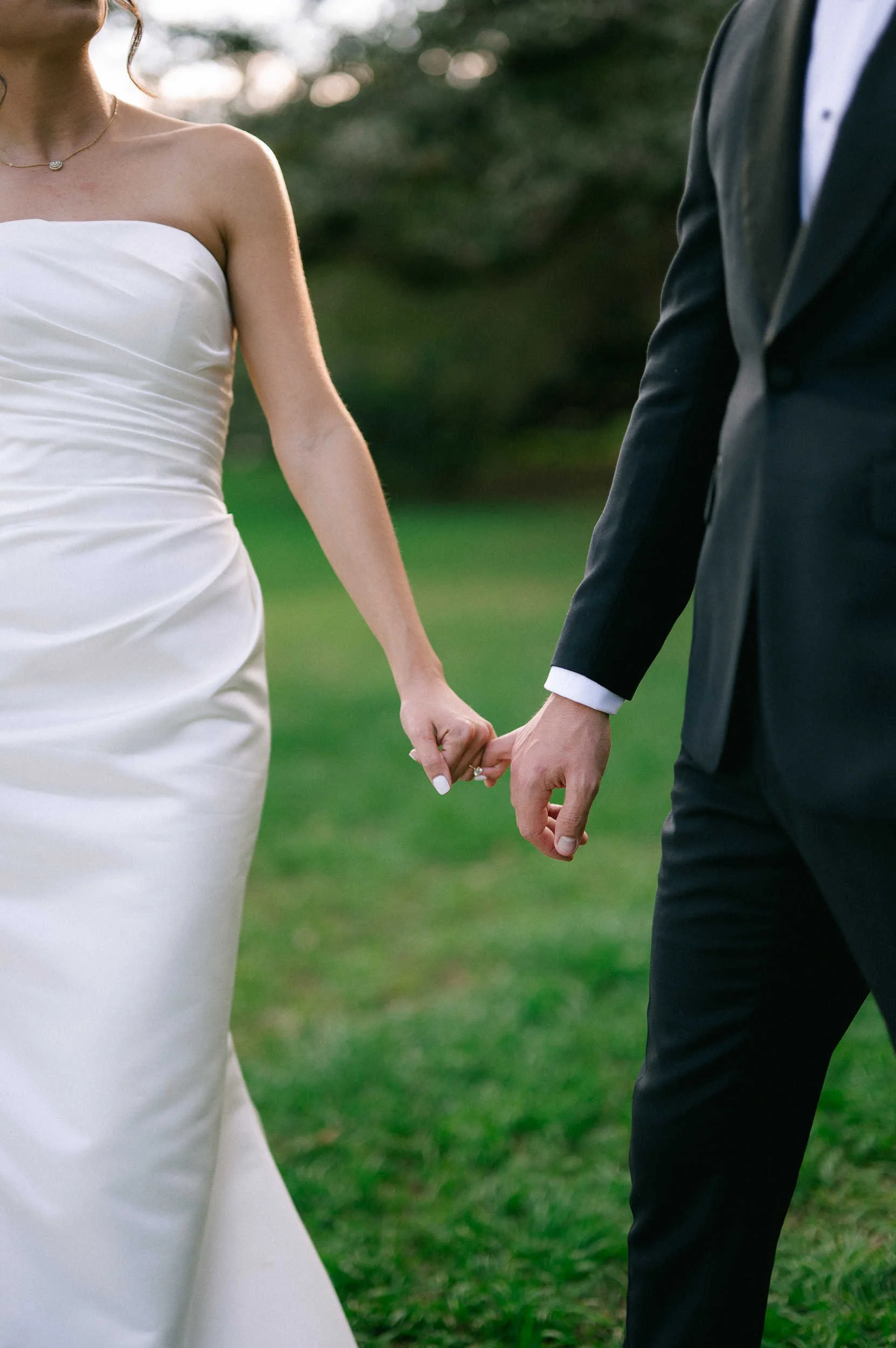 candid photo of couple on their wedding day with their pinky fingers interlocked