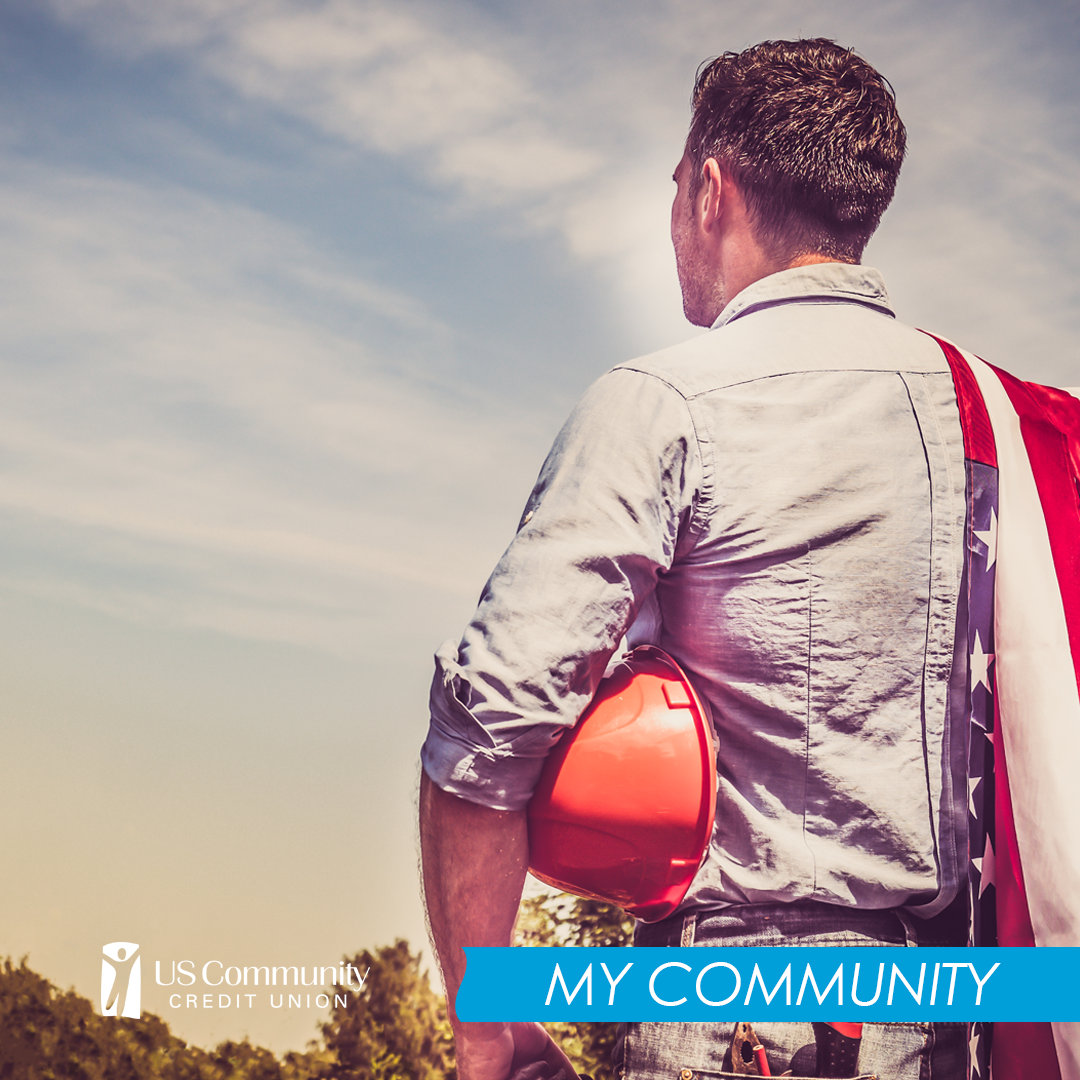 Man outside holding a hard hat with the American flag over his shoulder with his back to the camera.