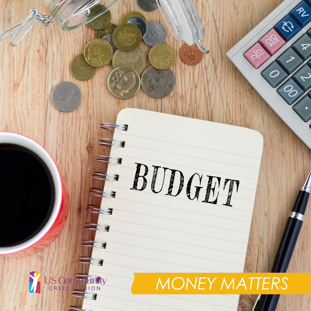 Notebook that says budget with a cup of coffee, coins, a pen and a calculator around it.