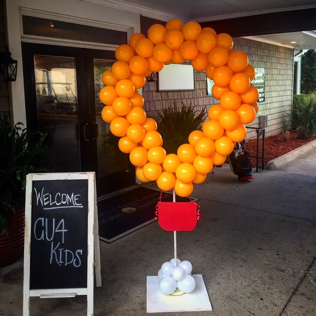 A ring of balloons next to a sign reading “Welcome CU4 Kids”