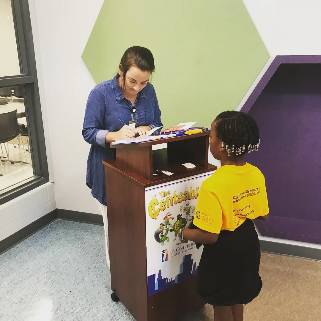 A young student standing in front of a podium reading “Censtables”