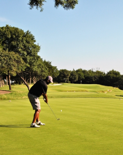 Kenny hits his tee shot to the par 3 third hole green.