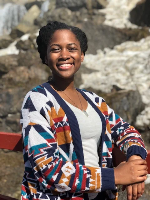 Pictured: Emani smiling seated outside
