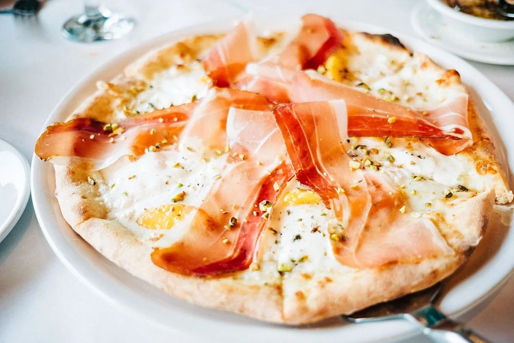 Peaches & Cream Pizza: House grown peaches, speck, artisan Burrata, caramelized onions, micro arugula, basil, white sauce