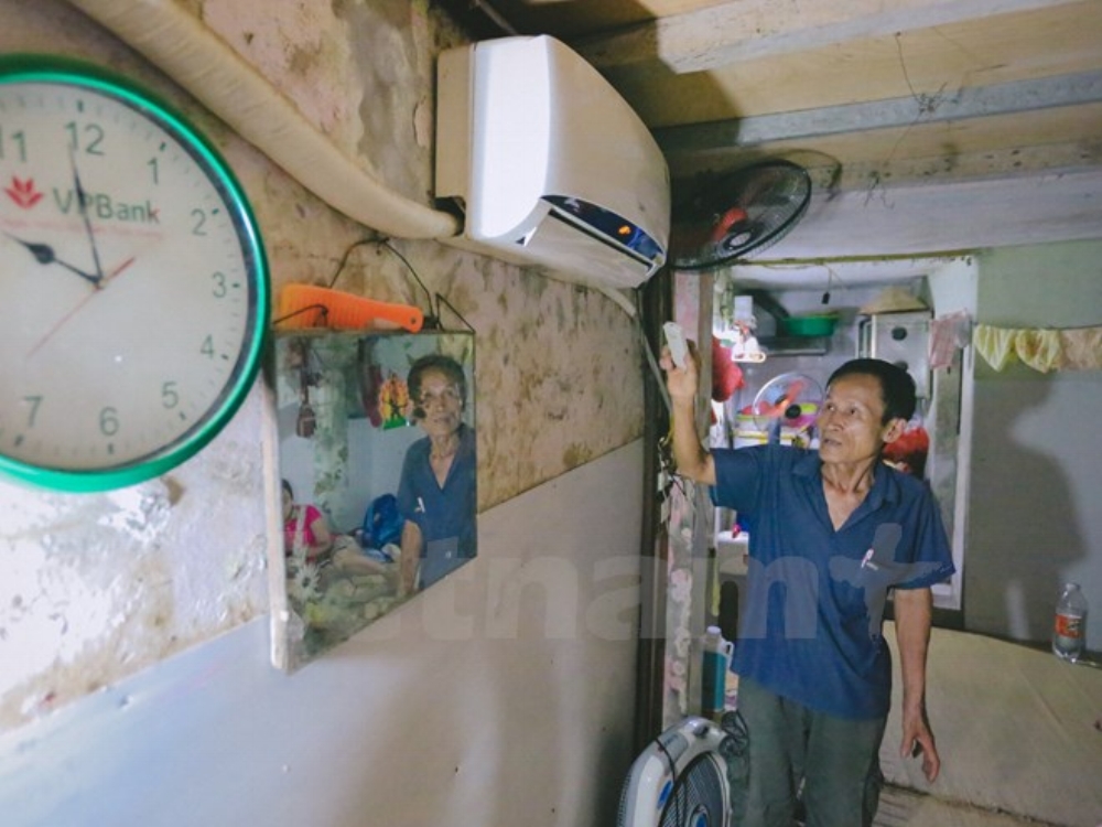 Mỗi ngày, ông lại tự đi thăm hỏi mỗi phòng trọ, đồng thời nhắc nhở mọi người sử dụng điều hòa tiết kiệm trong đợt cao điểm nắng nóng này. (Ảnh: Minh Sơn/Vietnam+)