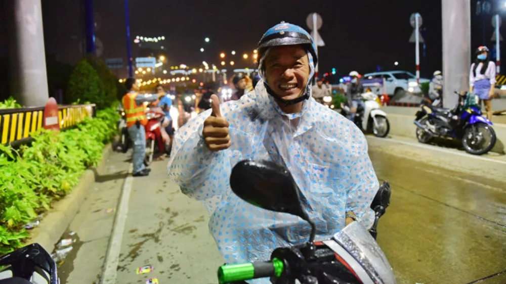 Anh Trương Văn Huân cảm kích khi được tặng áo mưa - Ảnh: HỮU THUẬN